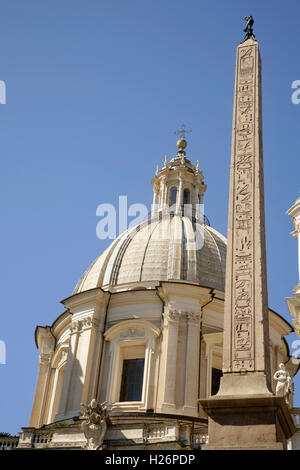 Spalte des Fiumi Brunnen auf der Piazza Navona, Rom, Italien mit der barocken Chiesa di Sant'Agnese in Agone hinter. Stockfoto