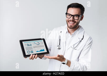 Lächelnd, bärtige Arzt Tablet halten. Stockfoto