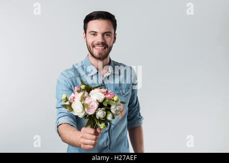 Glücklichen hübscher junger Mann hält einen Blumenstrauß. Stockfoto