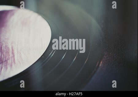 LP Rekord Abschnitt extreme Nahaufnahme, Nuten schwarz Detail und lila defokussierten label Stockfoto