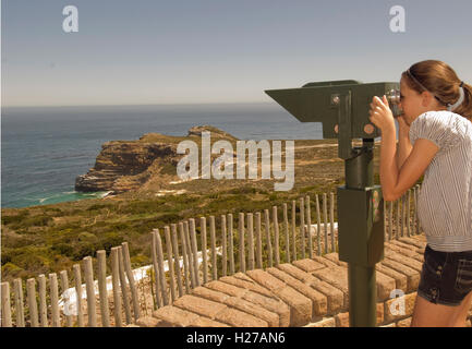 Ein Mädchen betrachten durch ein Fernglas in Richtung Cape Point und den Atlantischen Ozean. Südafrika Stockfoto