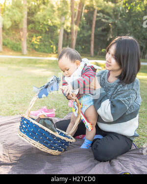 Mutter Baby halten, wenn Familie Picknick im park Stockfoto