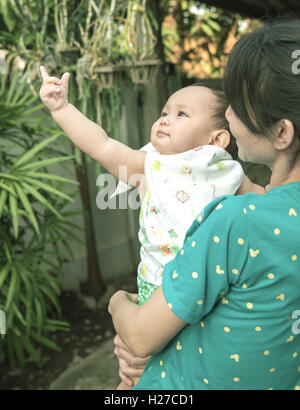 Baby Punkt Finger bis zu Himmel, Mutter halten baby Stockfoto