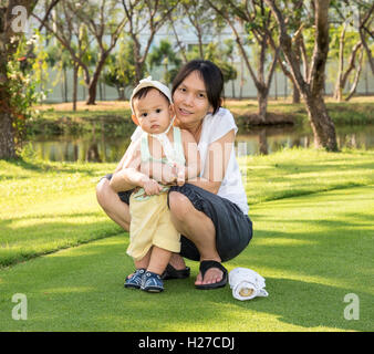 Mutter Baby halten, wenn Familie Picknick im park Stockfoto