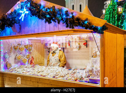 Vilnius, Litauen - 27. Dezember 2015: Mann mit den festlichen Hut die Lebkuchen waren am Weihnachtsmarkt auf dem Domplatz im Zentrum der Stadt Vilnius verkauft. Stockfoto