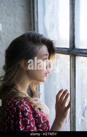 Profil einer schweren Frau aus dem Fenster Stockfoto
