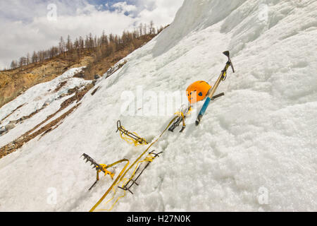 Helm, hausgemachte neue Steigeisen, Eispickel im Schnee Stockfoto