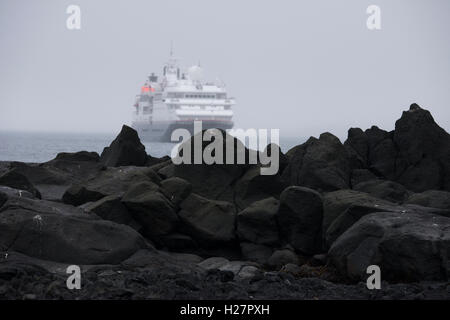 Andreanof Inseln, Alaska, Aleuten-Inselkette. Fernbedienung Seguam Insel (52-22-89 N 172-23-83 W) Vulkanlandschaft mit Schiff Stockfoto