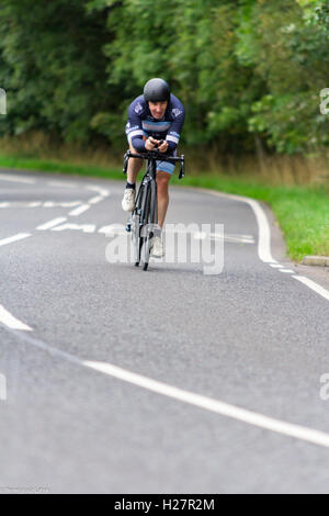 Beschleunigen professionell gekleidet Radfahrer auf dem Asphalt während des Wettbewerbs in Schottland Stockfoto
