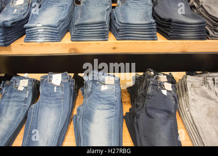 Store-Display, Jeans zusammengeklappt und gestapelt auf den Tischen Stockfoto