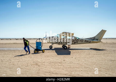 Pilot und sein Assistent füllen ein Flugzeug mit Benzin vor einem Flug nach Swakopmund, Namibia Stockfoto