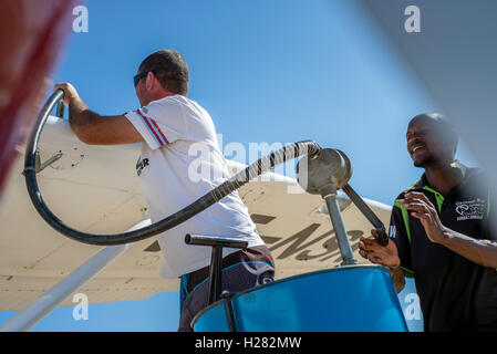 Pilot und sein Assistent füllen ein Flugzeug mit Benzin vor einem Flug nach Swakopmund, Namibia Stockfoto