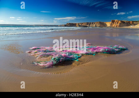 Kunststoff-Abfälle und Rückstände von großen Fischernetzen gestrandet am Strand von Tonel Strand, Portugal Stockfoto