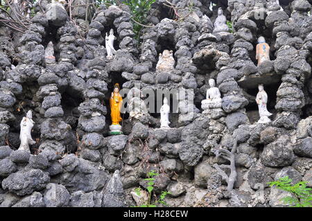 Cam Ranh, Vietnam - 9. Februar 2016: Viele Buddha-Statuen sind in viele kleine Löcher in eine Wand aus Muschel in einer Pagod setzen Stockfoto