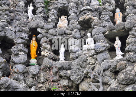 Cam Ranh, Vietnam - 9. Februar 2016: Viele Buddha-Statuen sind in viele kleine Löcher in eine Wand aus Muschel in einer Pagod setzen Stockfoto