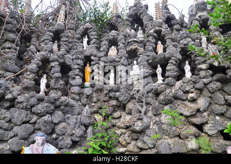 Cam Ranh, Vietnam - 9. Februar 2016: Viele Buddha-Statuen sind in viele kleine Löcher in eine Wand aus Muschel in einer Pagod setzen Stockfoto