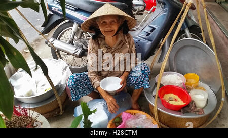 Saigon, Vietnam - 27. November 2015: Eine alte Frau ist street Essen auf der Straße von Saigon zu verkaufen Stockfoto