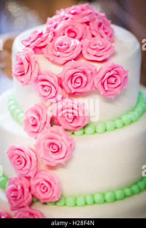 Eine wunderschöne Hochzeitstorte, dekoriert mit rosa Rosen aus Marzipan hergestellt in Nahaufnahme Stockfoto