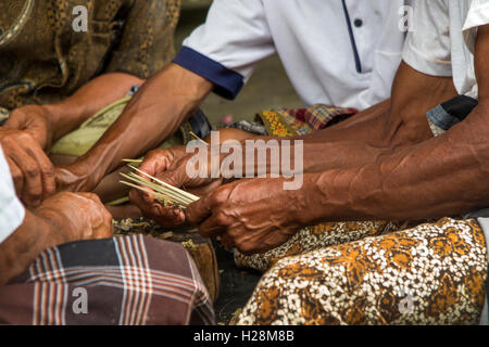 Indonesien, Bali, Tampaksiring, Gunung Kawi Tempel, Hände der Männer Kuningan Festival Satay vorbereiten Stockfoto