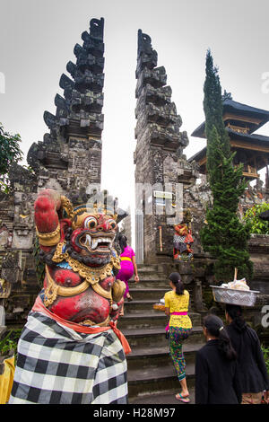 Indonesien, Bali, Batur, Pura Ulun Danu Batur Tempel Eingang Anbeter mit Kuningan Angebote Stockfoto