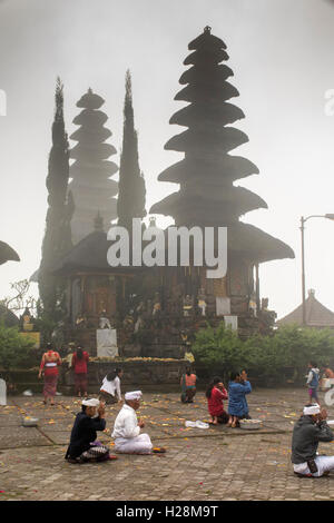 Indonesien, Bali, Batur, Pura Ulun Danu Batur Kuningan Festival Gläubige beten in niedrigen Wolken am frühen Morgen Stockfoto