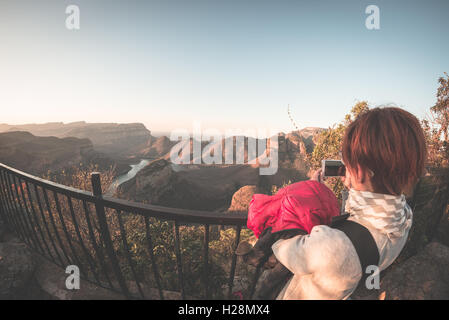 Blyde River Canyon, berühmte Reiseziel in Südafrika. Touristen nehmen Foto mit Smartphone bei Sonnenuntergang von der Terrasse ein Stockfoto