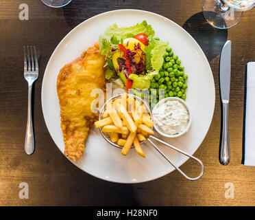 Fish And Chips mit Erbsen auf einem Teller serviert, mit Salat und Remoulade Stockfoto