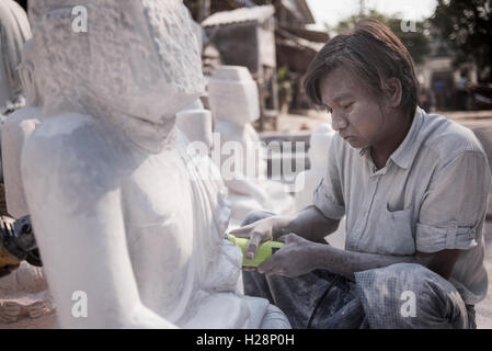 Ein Mann schnitzen einen Marmor Buddha-Statue mit einem Winkelschleifer, Amarapura, in der Nähe von Mandalay, Myanmar. Stockfoto