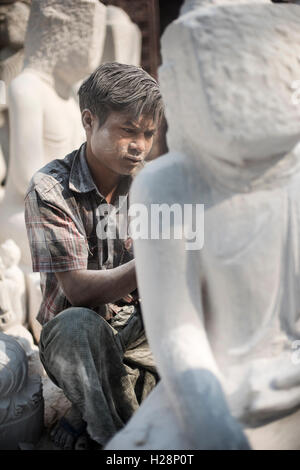 Ein Mann schnitzen einen Marmor Buddha-Statue mit einem Winkelschleifer, Amarapura, in der Nähe von Mandalay, Myanmar. Stockfoto