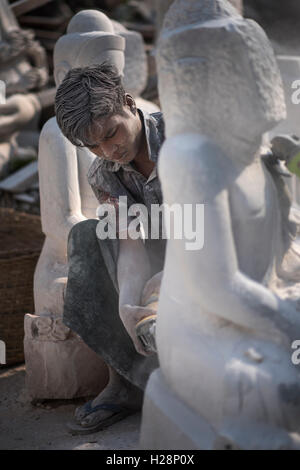 Ein Mann schnitzen einen Marmor Buddha-Statue mit einem Winkelschleifer, Amarapura, in der Nähe von Mandalay, Myanmar. Stockfoto