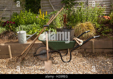 Eine Schubkarre und Garten Werkzeuge und einem kleinen Bett angehoben Stockfoto