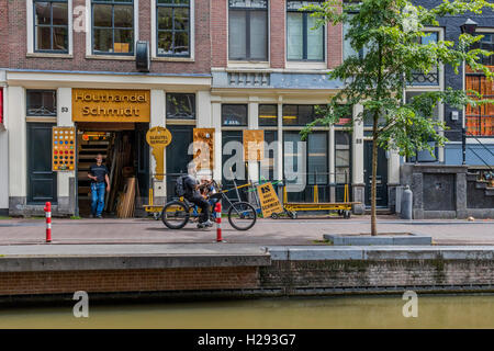 Zyklus mit Reiter getan bis zu schauen wie Motorrad Schwein unterwegs von Seite der Gracht in Amsterdam Holland Stockfoto
