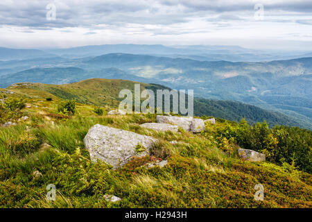 Berg-Sommer-Landschaft. Wiese mit großen Steinen unter dem Rasen über die Hügel in der Nähe der Spitze des Gebirges Stockfoto