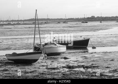 Schwarz / weiß Bild von drei Booten gestrandet im Schlamm bei Ebbe auf dem Nore Rithe Emsworth Hampshire Uk Stockfoto