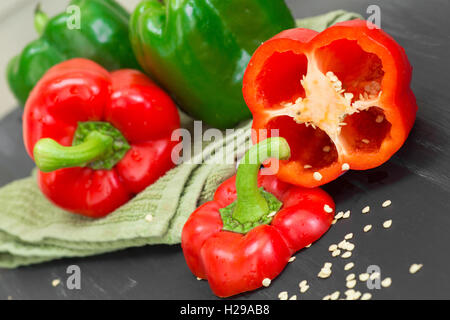 Rote und grüne Paprika mit Samen wird an Bord in Scheiben geschnitten Stockfoto