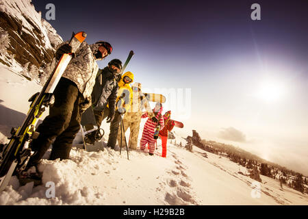 Snowboarder posiert auf blauen Himmel Hintergrund in Bergen Stockfoto
