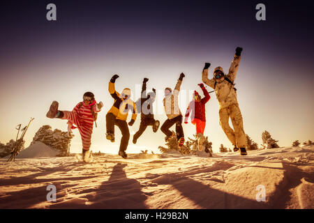 Snowboarder posiert auf blauen Himmel Hintergrund in Bergen Stockfoto