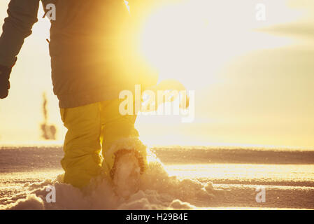 Snowboarder geht in Schneewehe auf dem Sonnenlicht-Hintergrund Stockfoto