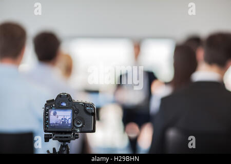 Kamera auf Stativ auf Pressekonferenz von Geschäftsleuten Stockfoto