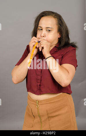 Erwachsene Frau, die versucht, einen langen Ballon in die Luft sprengen Stockfoto