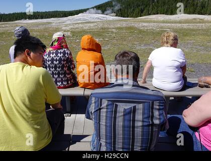 Menschen beobachten Dampf Aufstieg vom Old Faithful Geysir, wartet es ausbrechen. Yellowstone-Nationalpark Stockfoto