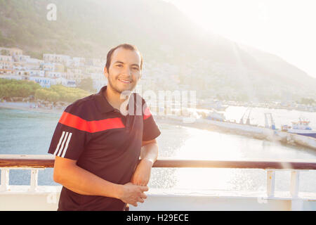 Junger Mann lächelt und schaut in die Kamera auf dem Boot Reisen in Griechenland Stockfoto