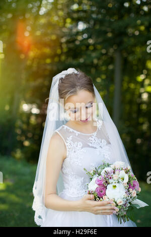 Wunderschönen Brautstrauß in Händen der jungen Braut gekleidet in weißen Brautkleid. Stockfoto