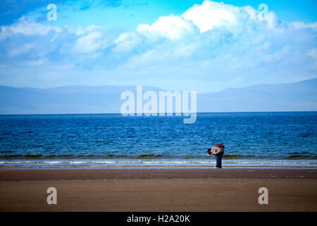 Eine einsame weibliche Frau entlang der Strand in Findhorn Bay in Schottland beachcoming entlang der Weise, Schottland, Großbritannien Stockfoto