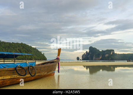 Longtail-Boot auf Ko Phi Phi Don Strand bei Ebbe mit Reflexion der Berge in Thailand Stockfoto