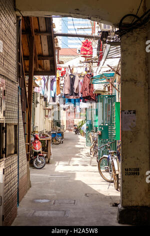 Hutong mit Aufhängen von Wäsche und geparkte Fahrräder in Shanghai, China Stockfoto
