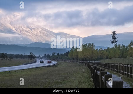 Straße zur Sonne beleuchtet Jade Dragon Snow Mountain bei Sonnenaufgang im Ganhaizi in China Stockfoto