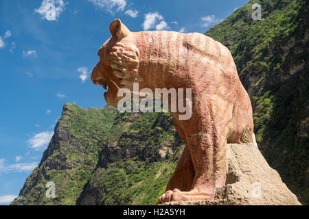 Rock-Statue der Tiger auf der Suche nach hinten in Richtung der Berge in Yunnan, China Stockfoto