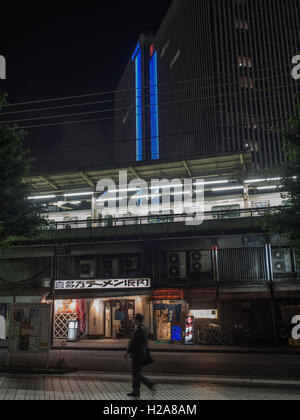 Tokyo nach Einbruch der Dunkelheit. Yamamote Linie Zug an einer weiter erhöhten Schienen über Nacht Straße mit einsamen Fußgänger. Gaado-Shita, Yurakucho, Tokyo, Japan Stockfoto