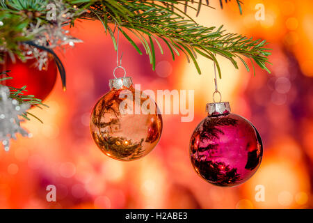 Shiny Christmas baubles hanging on a branch on a pine tree Stockfoto